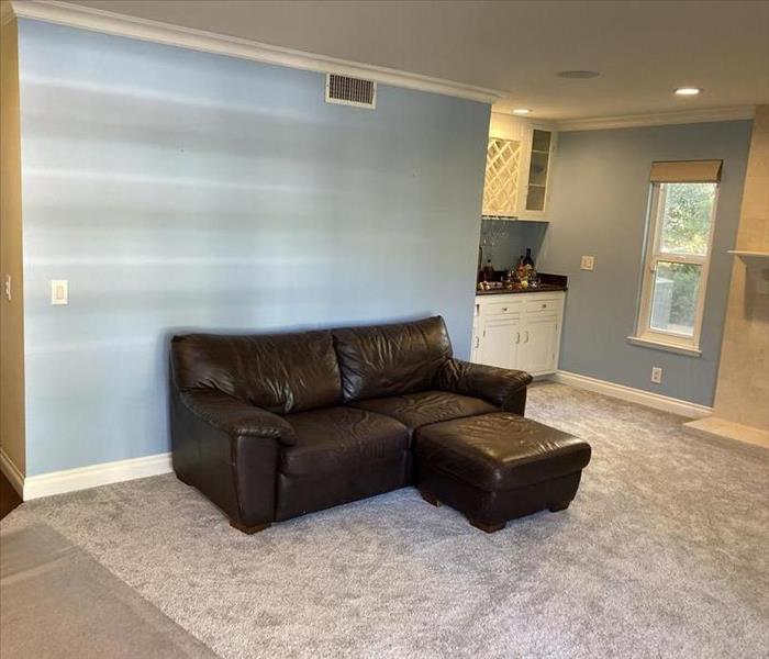 fully reconstructed family room with new carpet and drywall 